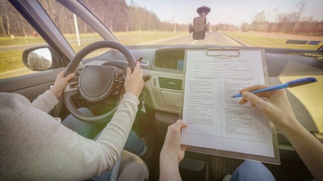 Examiner filling in driver's license road test form