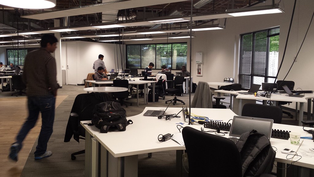Developer walking through a contemporary open office, open, agile, development space, desks,